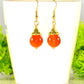 12mm Natural Carnelian Crystal Drop Earrings displayed on a tea cup.