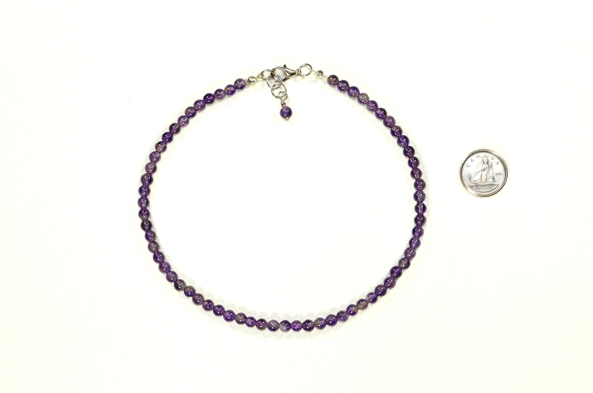 4mm Amethyst Crystal Choker Necklace beside a dime.