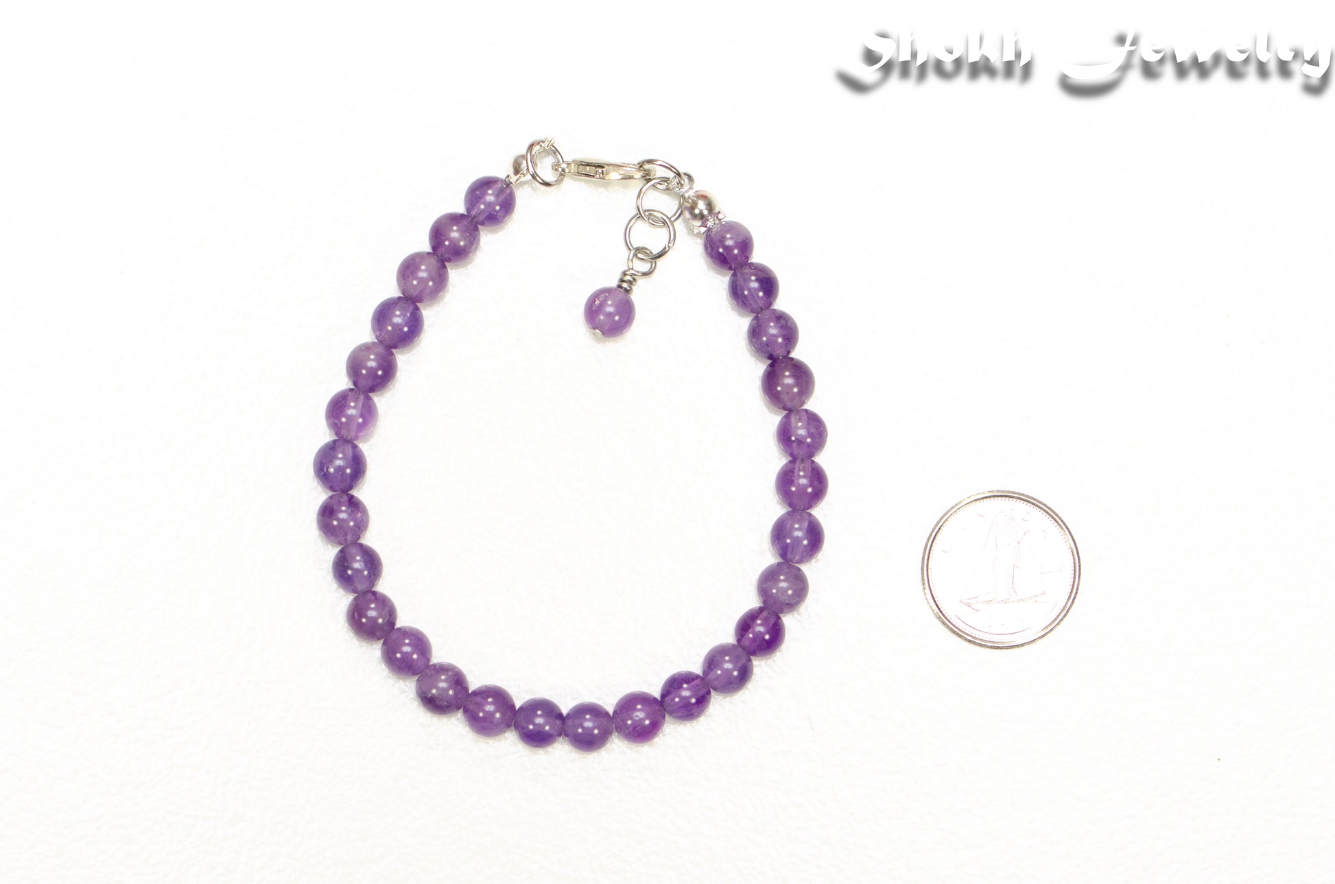 6mm Amethyst Crystal Bracelet beside a dime.
