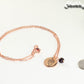 Rose Gold Plated January Birth Flower Necklace with Garnet Birthstone Pendant beside a dime.