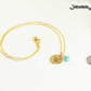 Gold Plated December Birth Flower Necklace with Turquoise Howlite Birthstone Pendant beside a dime.