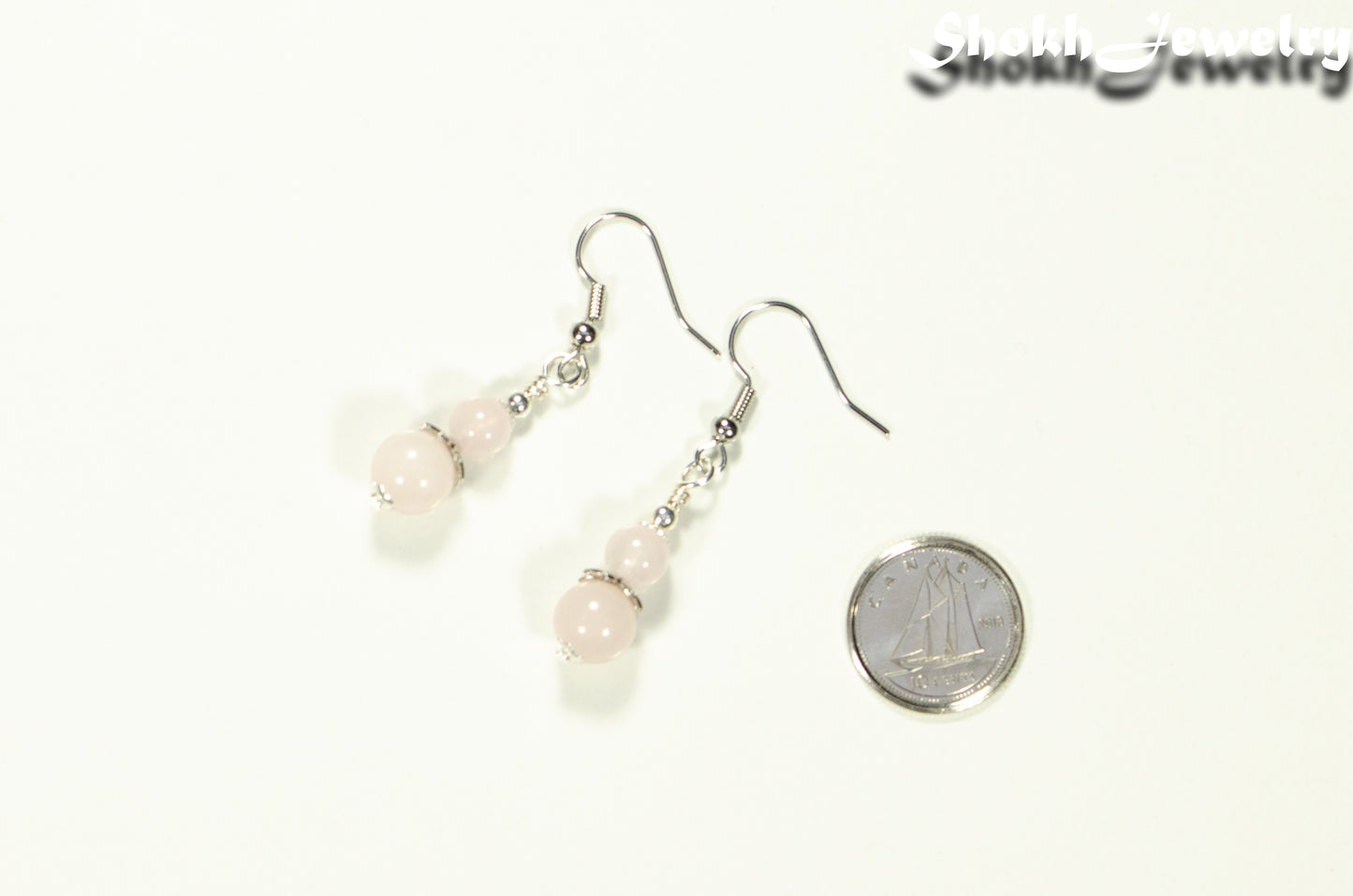 Small Rose Quartz Earrings beside a dime.
