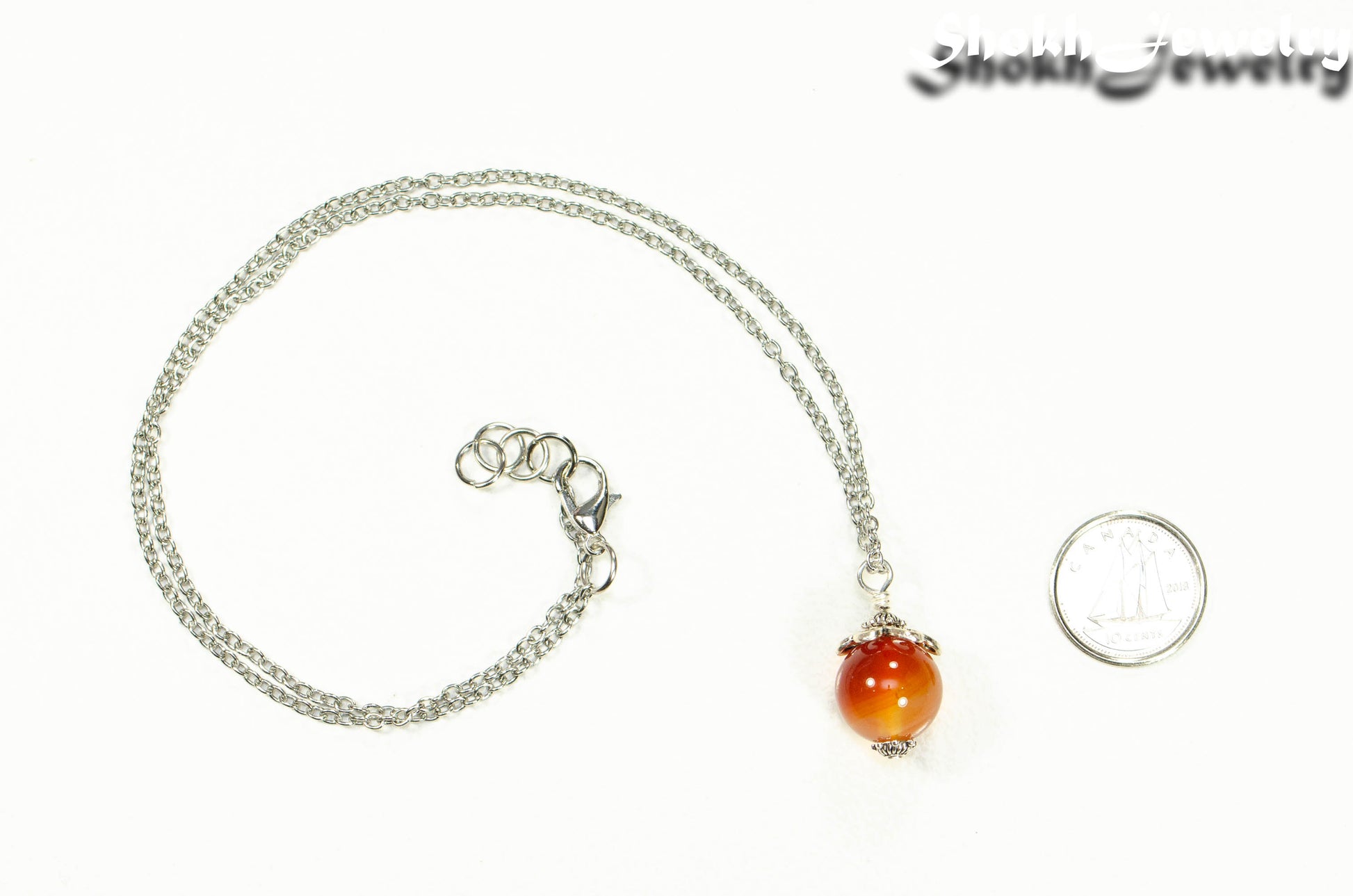 12mm Carnelian Pendant Necklace beside a dime.