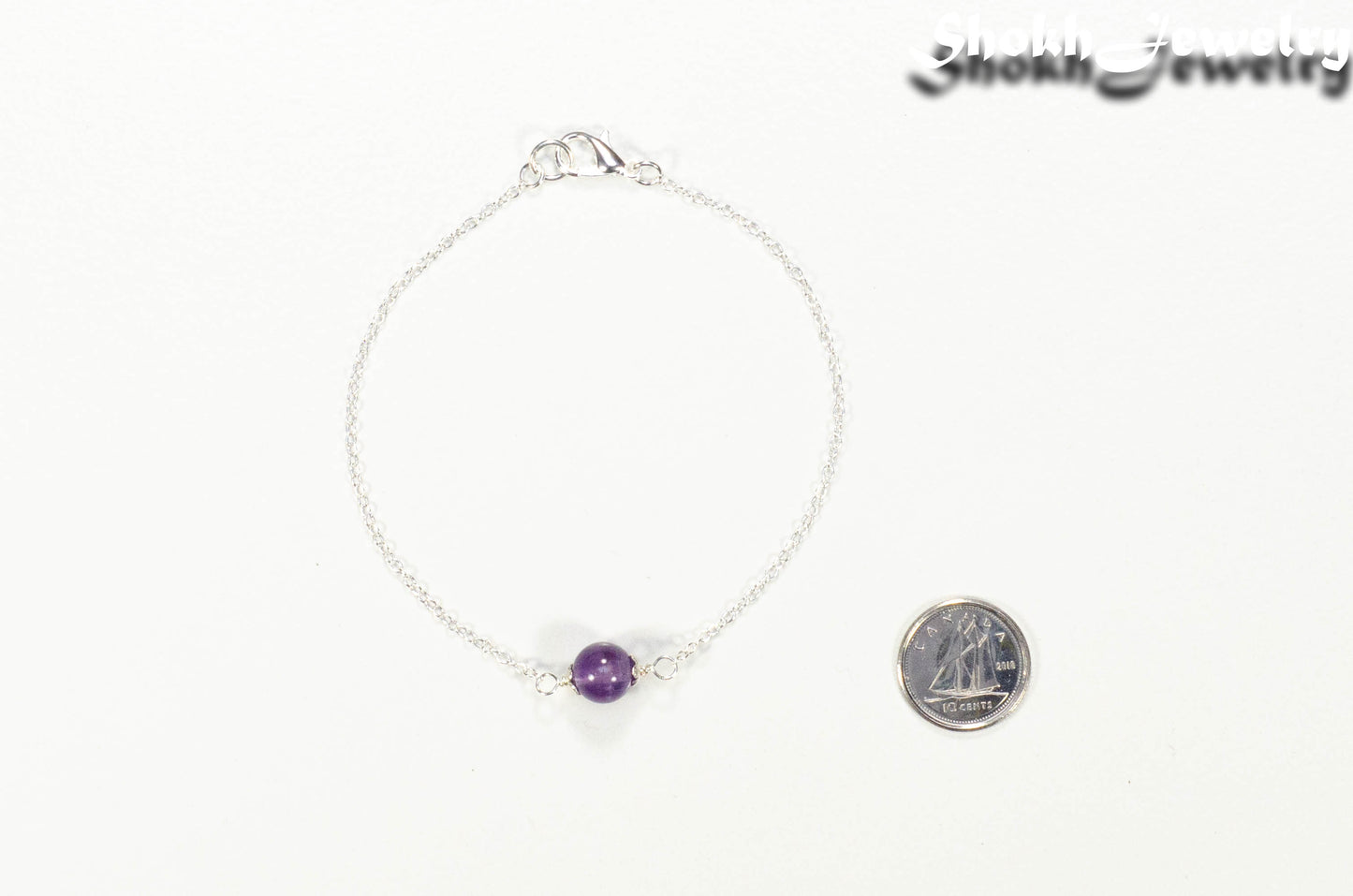 Minimal Amethyst Bracelet beside a dime.
