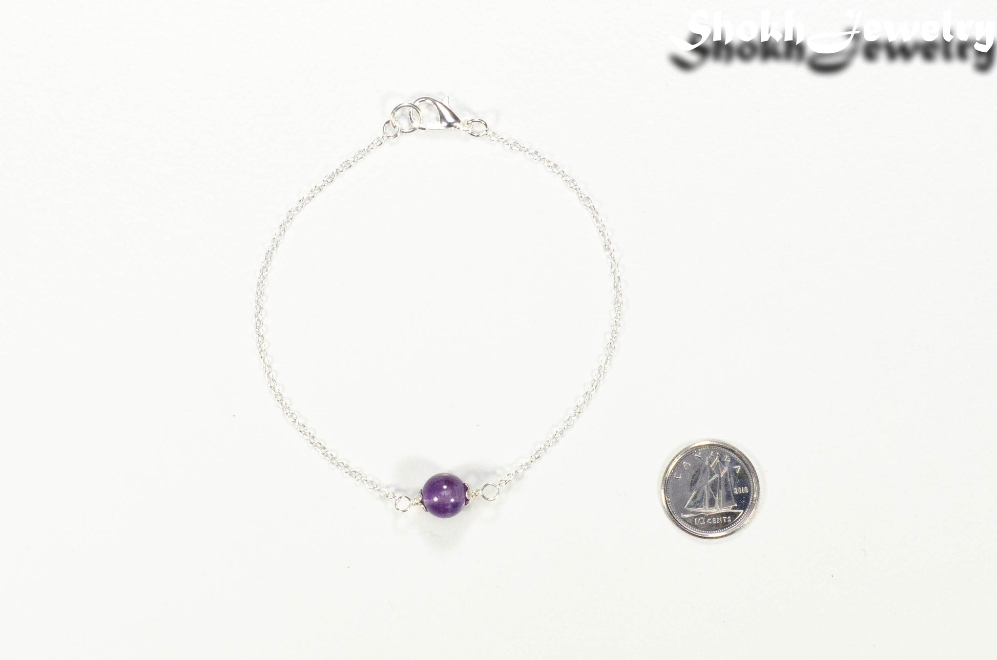 Minimal Amethyst Bracelet beside a dime.