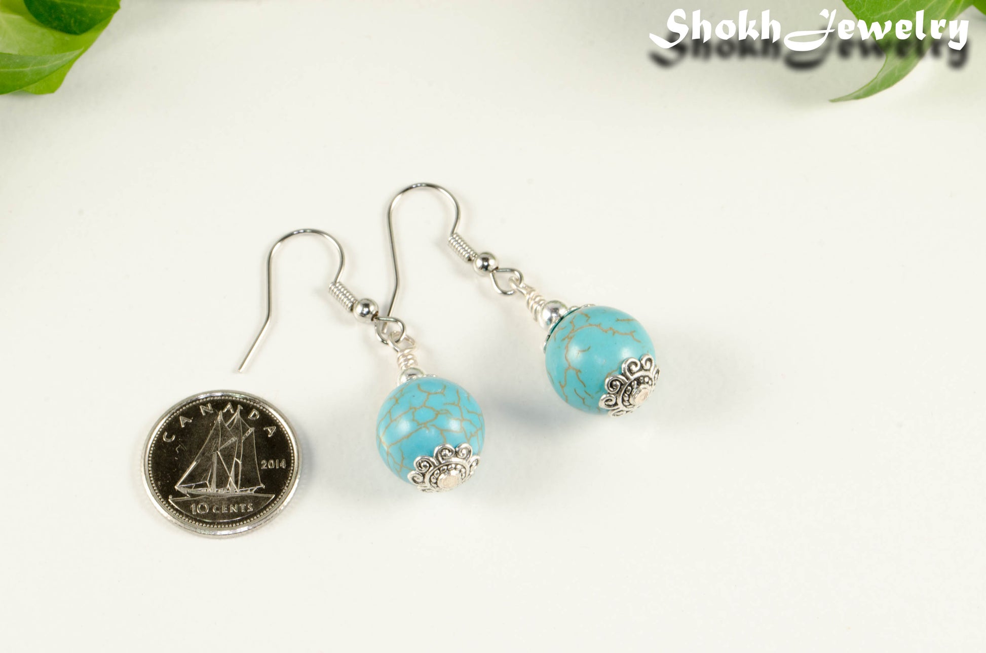 12mm Turquoise Howlite Dangle Earrings beside a dime.