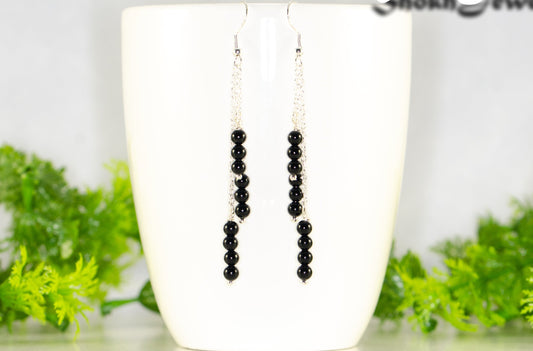 Silver Plated Chain and Black Obsidian Crystal Earrings displayed on a coffee mug.