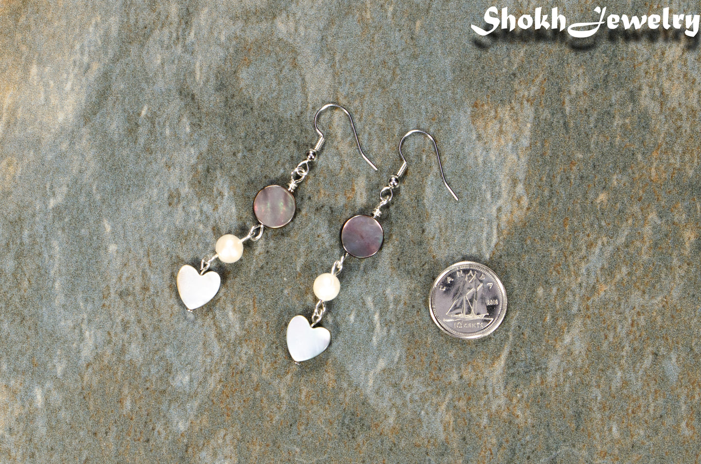 Grey Seashell and White Pearl Earrings beside a dime.