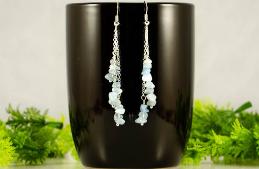 Long Silver Plated Chain and Aquamarine Crystal Chip Earrings on a mug
