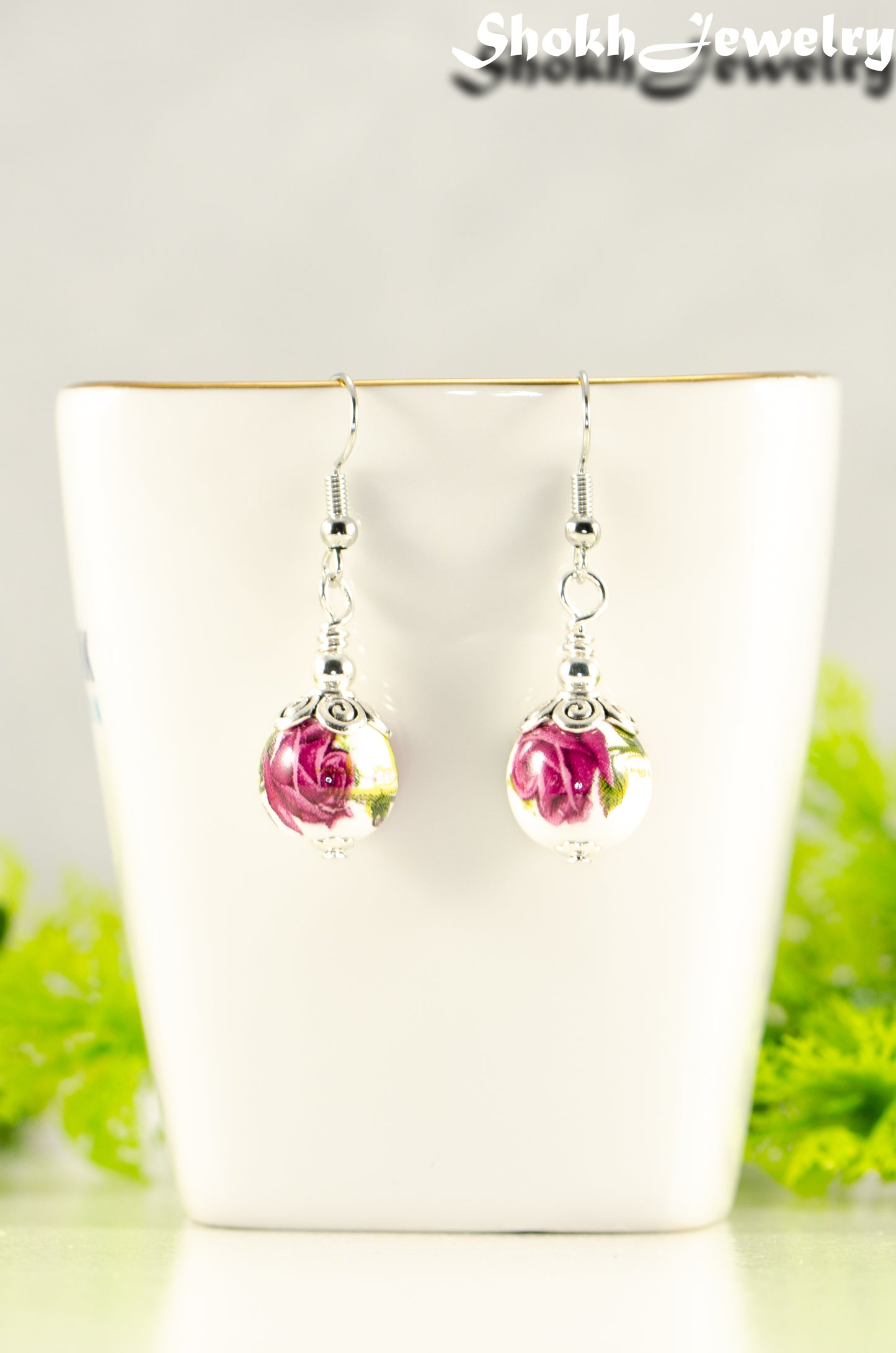 12mm Ceramic Pink Flower Earrings displayed on a tea cup.