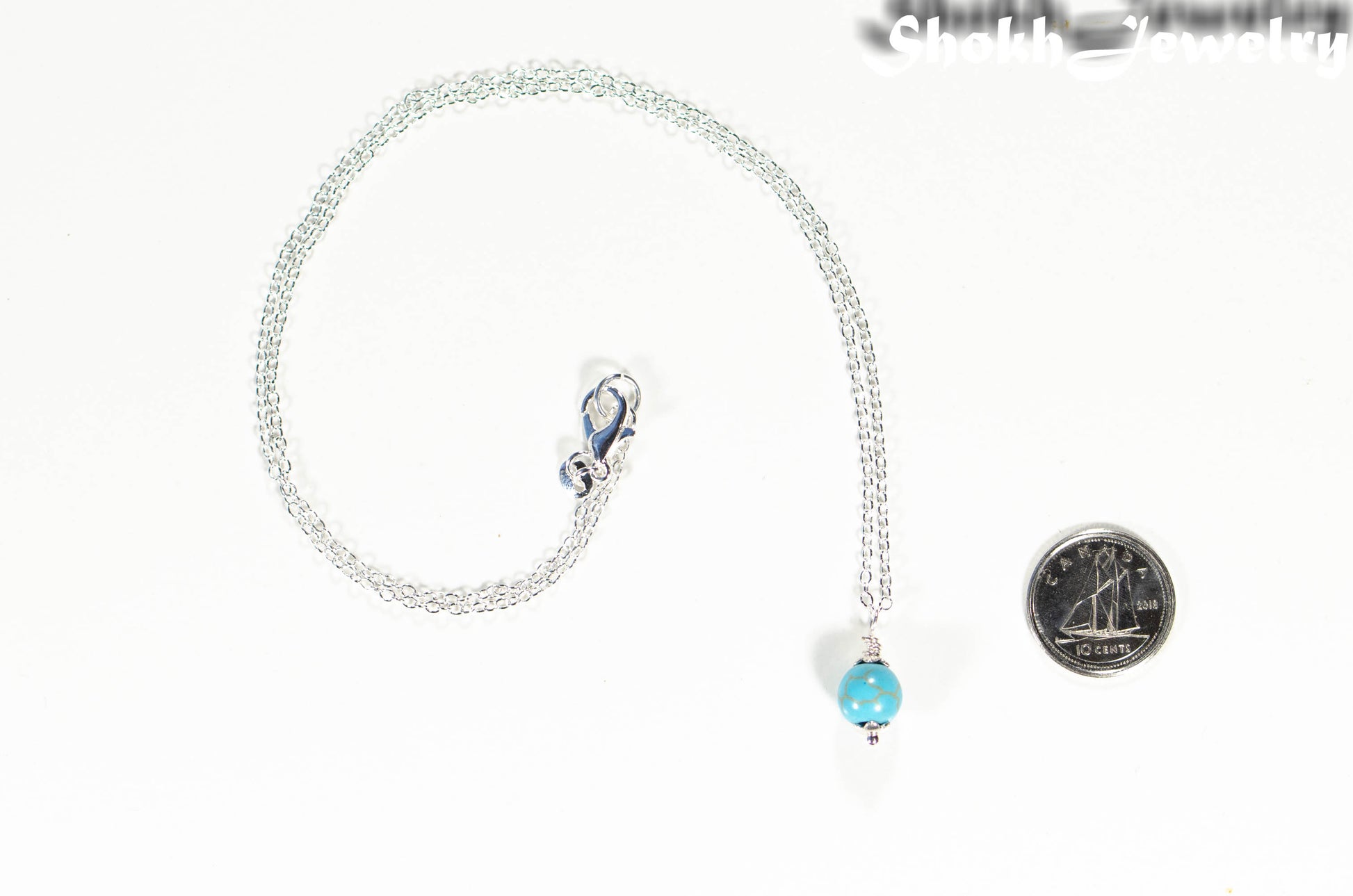 Dainty Turquoise Howlite Choker Necklace beside a dime