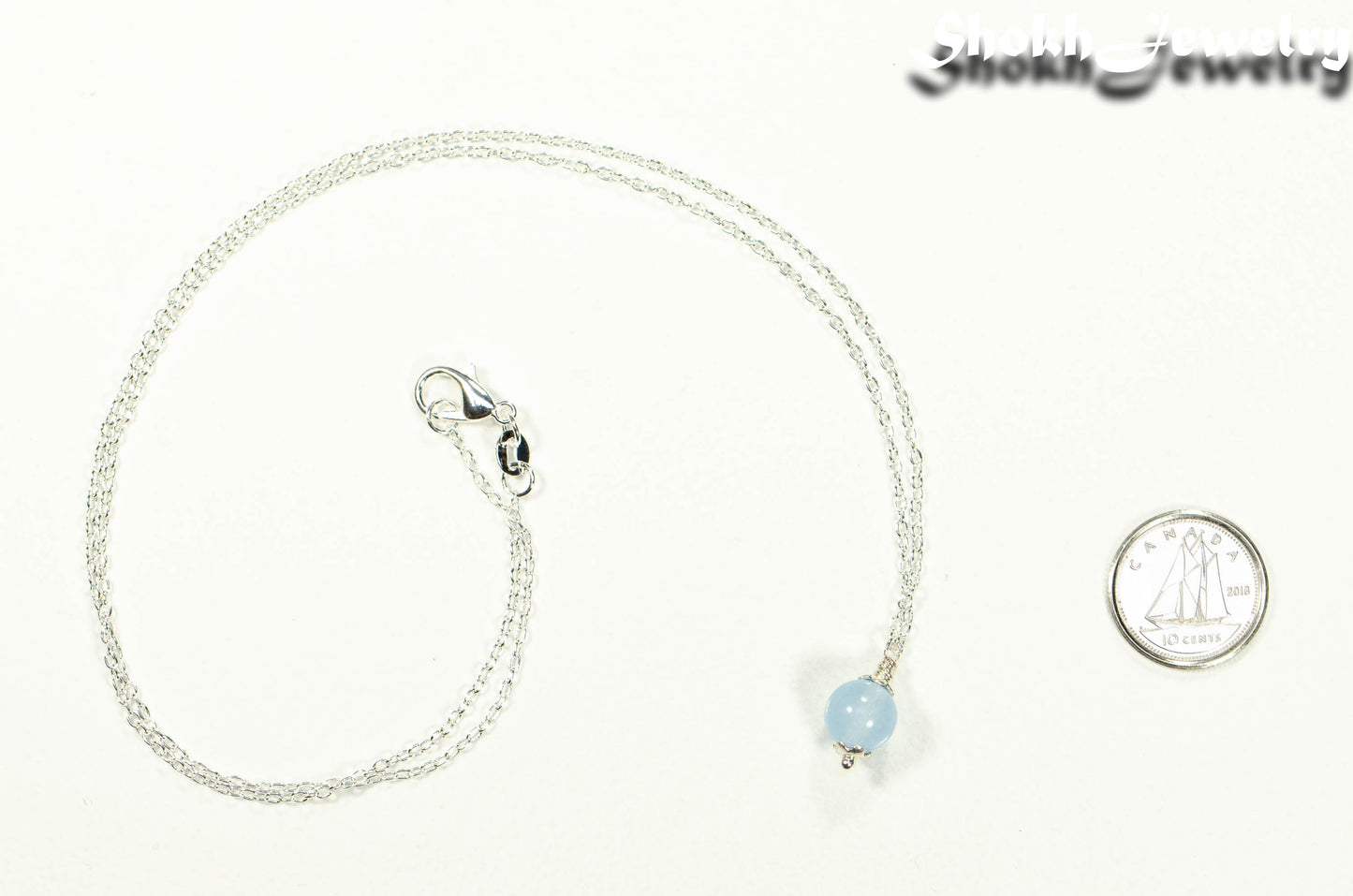 Dainty Aquamarine Choker Necklace beside a dime