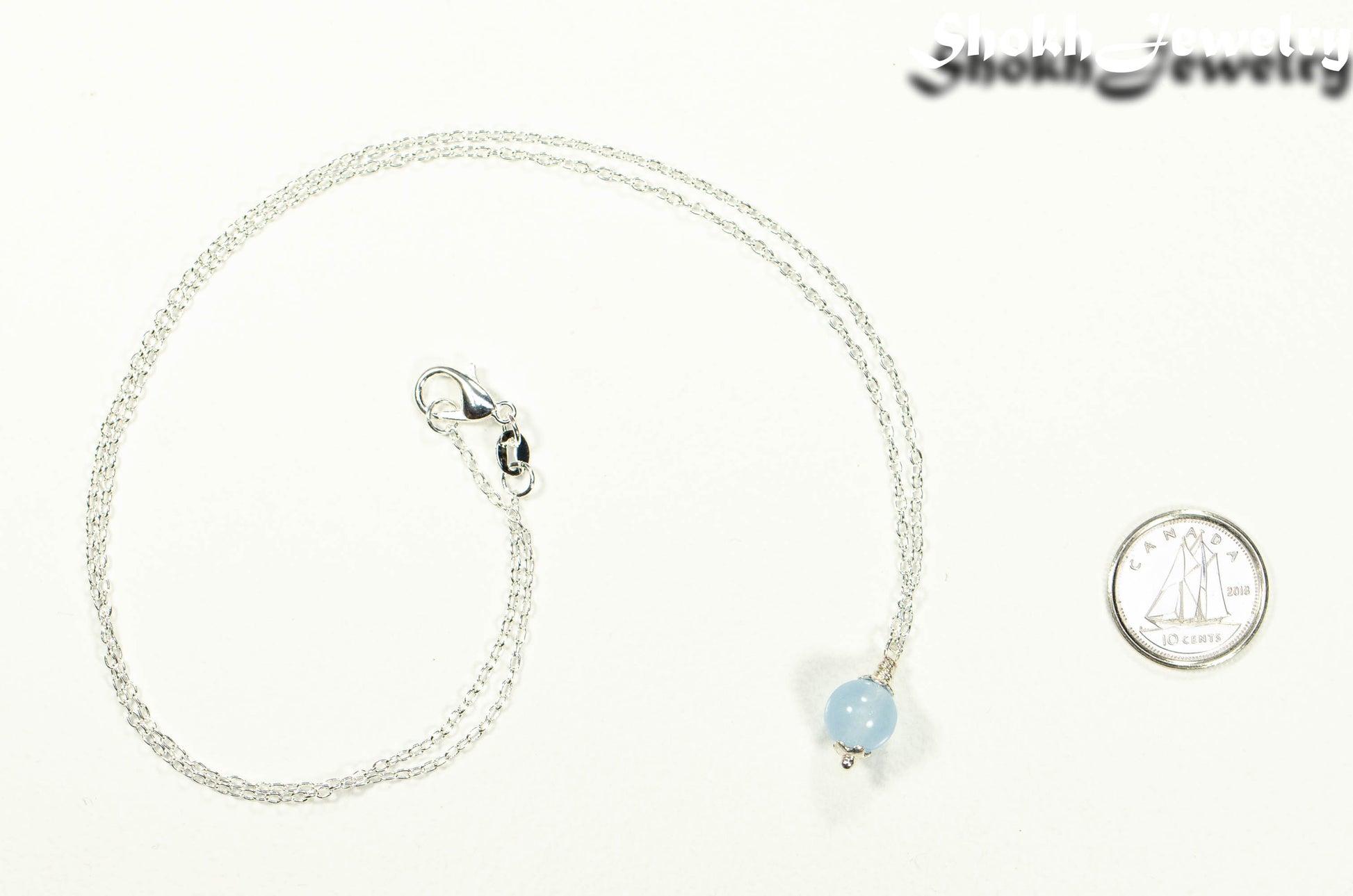Dainty Aquamarine Choker Necklace beside a dime